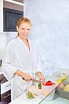 Woman Making Fruit Salad In Kitchen Stock Photo