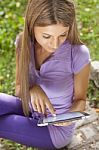 Woman Using Tablet Computer In Park Stock Photo