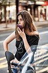 Woman With Smartphone On Motorbike Stock Photo