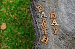 Wooden Earth Day Word On Wood Log Background. Save The Earth Idea Stock Photo