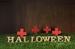 Wooden Halloween Words And Wooden Cross On Grass Background Stock Photo