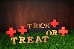 Wooden Trick Or Treat Words And Wooden Cross On Grass Background Stock Photo