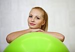 Young Attractive Blond Woman Smiling From Behind A Fitness Ball Stock Photo