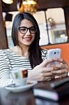 Young Beautiful Woman Using Her Mobile Phone In Coffee Stock Photo