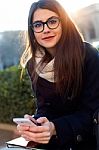 Young Beautiful Woman Using Her Mobile Phone In The Street Stock Photo