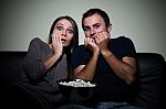 Young Couple Watching Scary Movie On Tv Stock Photo