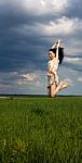 Young Girl Jumping On The Field Stock Photo