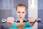 Young Woman Exercising With Dumbbells At The Gym Stock Photo
