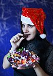Young Woman In Santa Hat With Candy Stock Photo