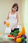Young Woman Making Fruit Smoothie In Blender Stock Photo