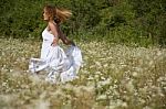 young Woman running In Meadow Stock Photo