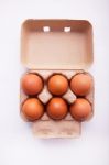 Chicken Eggs In Egg Box On White Wooden Background Stock Photo