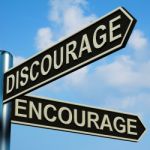 Discourage Or Encourage Directions On A Signpost Stock Photo