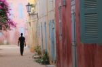 Silhouette Of A Man In A Colored Street Of Goree Island In Senegal Stock Photo