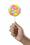 Hand Holding Colorful Spiral Lollipop Candy On Stick Stock Photo