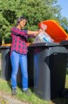 Standing Dutch Woman Dropping Plastic Waste In Trash Bin Stock Photo