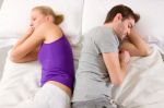 Couple Lying In Bed Back-to-back Stock Photo