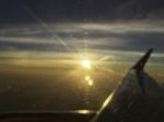 Airplane Window Focus With Sun Set On Horizon Cloud Sky Through Stock Photo