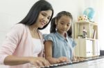 Little Asian Girl Playing Piano With Mother Stock Photo
