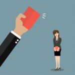 Hand Of Boss Showing A Red Card To Woman Employee Stock Photo