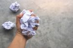 Human Hand Holding Crumpled Paper Ball On Cement Background Stock Photo