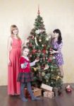 Two Young Women And Little Girl Near A Christmas Tree Stock Photo
