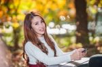 Beautiful Woman Smiling And Hand Holding Smartphone In Fall Forest Park Stock Photo