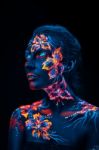 Beautiful Flowers In Uv Light On A Young Girl Face And Body Stock Photo
