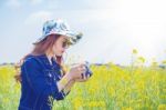 Woman Taking Photos At A Rapeseed Flowers. Vintage Tone Style Stock Photo