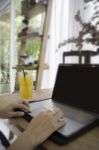 Woman With Laptop And Orange Juice At Table Stock Photo