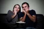 Young Couple Watching Scary Movie On Tv Stock Photo