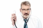 Senior Doctor Holding A Stethoscope Stock Photo
