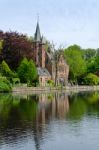 Flemish Style Castle Reflecting In Minnewater Lake In Bruges Stock Photo