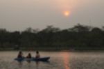 Blurred Image Of People Paddling Boat In Pond With Sunset In Par Stock Photo