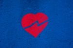 Broken Red Heart On Blue Wall Stock Photo