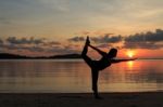 Silhouette Of Yoga Girl At Sunrise On The Beach Stock Photo
