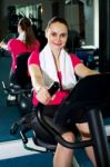 Cheerful Woman Doing Cycling At Fitness Centre Stock Photo