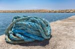 Coiled Blue Mooring Rope At Water In Greek Cave Stock Photo