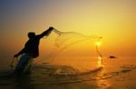 Throwing Fishing Net During Sunset Stock Photo