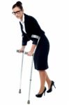Business Woman Walking With Help Of Crutches Stock Photo