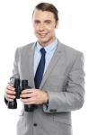 Smiling Male Consultant Holding Binoculars Stock Photo