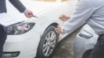 Insurance Agent Writing On Clipboard While Examining Car After A Stock Photo