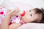 Beautiful Little Asian Girl Lying And Suck Up Milk Stock Photo