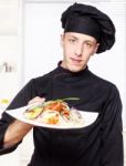 Chef In Black Uniform Offer Salad Stock Photo