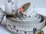 Miniature Woman Skating On Measuring Tape, Thinking Of Weight Lo Stock Photo