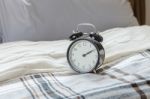 Modern Black Alarm Clock On Bed In Bedroom Stock Photo