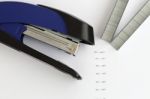 Blue Stapler With Staples And Paper On The Table, Selective Focu Stock Photo
