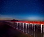 Red Bridge In The Night Sky With Star On Top Of The Sea Stock Photo