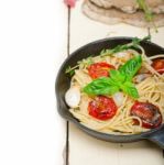 Spaghetti Pasta With Baked Cherry Tomatoes And Basil Stock Photo