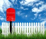 Red Postbox With White Fence Stock Photo